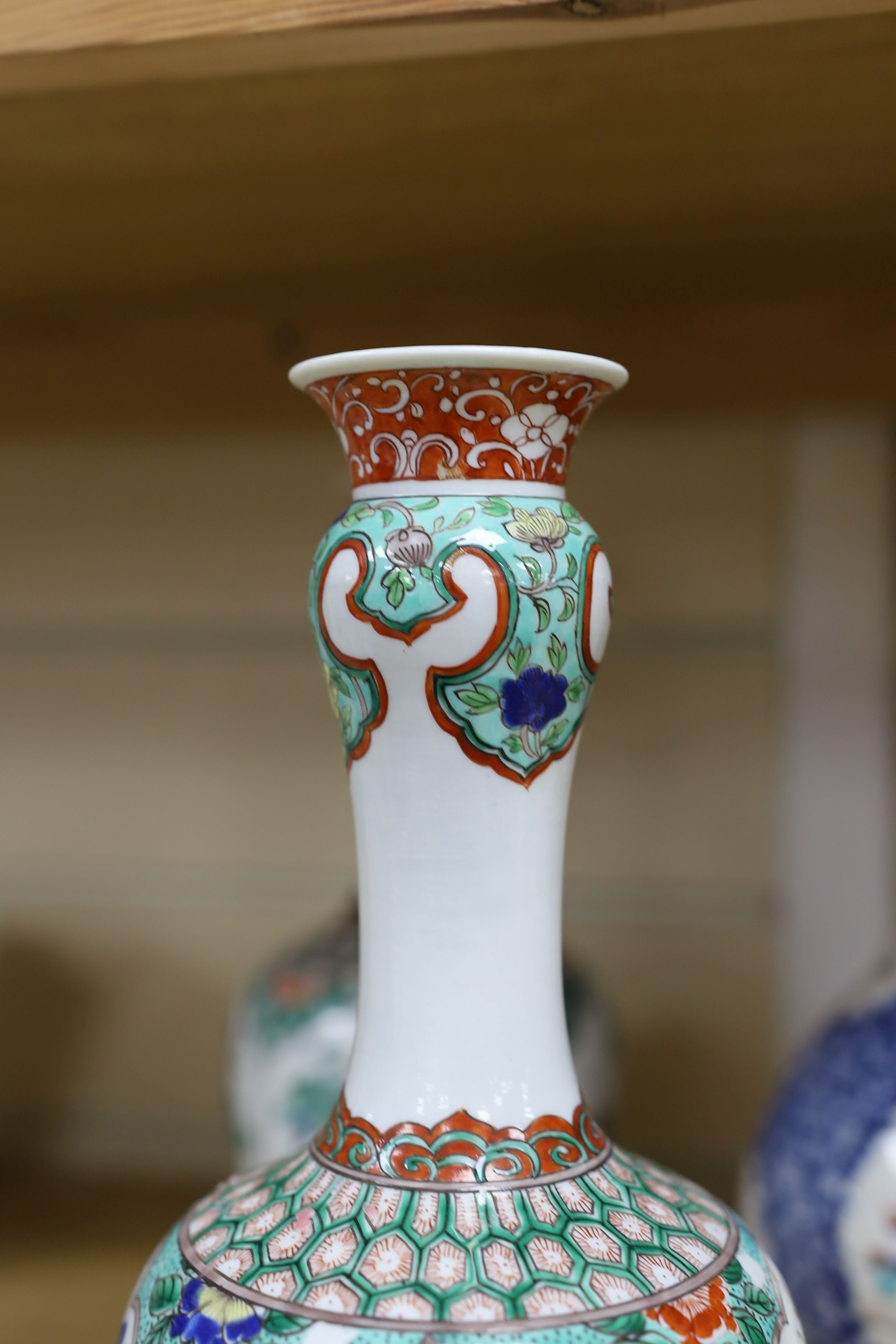 A pair Samson of Paris vases in the Chinese famille verte style and a Chinese Qianlong famille rose garlic neck vase with blue panelling motif, tallest 26cm